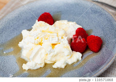 Catalan whey cheese, mato, served on plate with raspberries and honey Catalan whey cheese, mato, served on plate with raspberries and honey 110571868