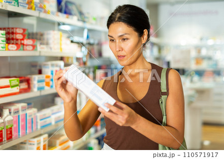 Woman choosing medicines in drugstore Woman choosing medicines in drugstore 110571917