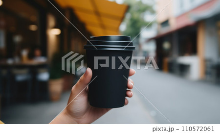 woman hand holding a blank black and paper coffee cup with no design woman hand holding a blank black and paper coffee cup with no design 110572061