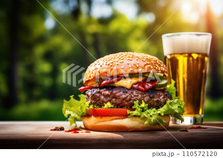 fresh burger on a wooden table with glass of cold fresh beer 110572120