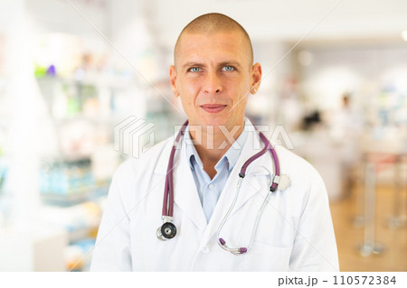 Portrait of positive friendly pharmacist or doctor in pharmacy 110572384
