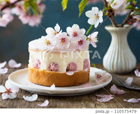 桜をバックにお皿に乗せたケーキ 110575479