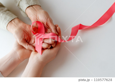 Hands of women with pink ribbon 110577628