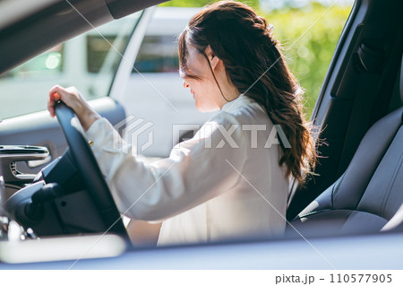 車の運転席に乗り込むビジネスウーマン（レンタカー・マイカー・乗車・安全運転） 110577905