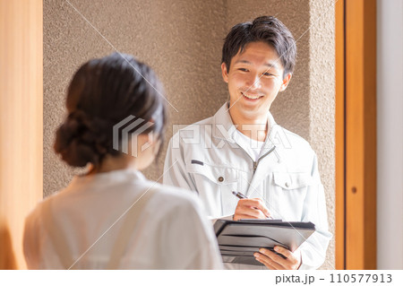 作業着姿のリフォーム・設備屋・工務店の男性と話を聞く主婦 作業着姿のリフォーム・設備屋・工務店の男性と話を聞く主婦 110577913