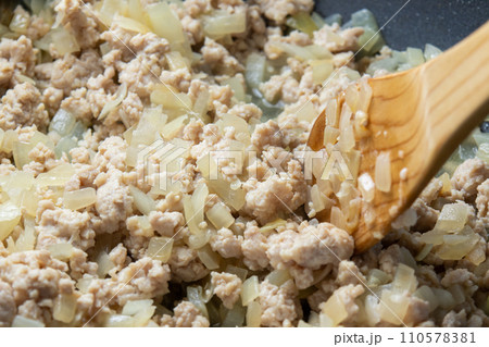 玉ねぎ(粗みじん切り)と鶏挽き肉をフライパンで炒める調理シーン。 玉ねぎ(粗みじん切り)と鶏挽き肉をフライパンで炒める調理シーン。 110578381