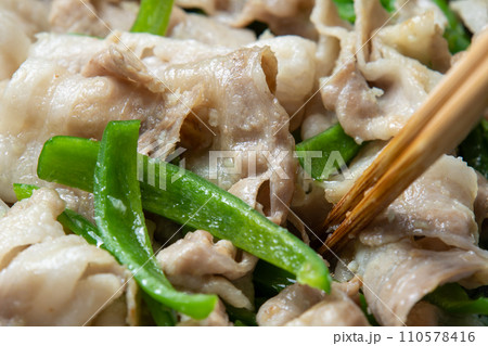 豚バラ肉とピーマンをフライパンで炒める調理シーン。 豚バラ肉とピーマンをフライパンで炒める調理シーン。 110578416