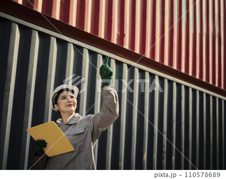 Female worker holding clipboard and showing pointing finger Female worker holding clipboard and showing pointing finger 110578689