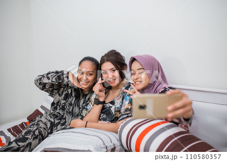 three best friends take a cell phone selfie in their pajamas three best friends take a cell phone selfie in their pajamas 110580357