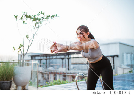 Attractive young woman stretching her arms before meditation at the resort Attractive young woman stretching her arms before meditation at the resort 110581017