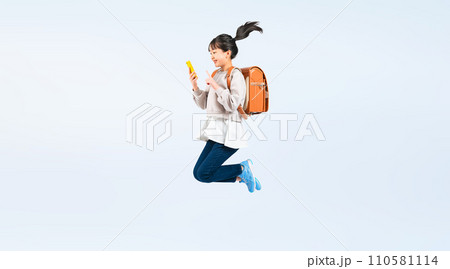 スマホを見ながらジャンプする女子小学生 スマホを見ながらジャンプする女子小学生 110581114