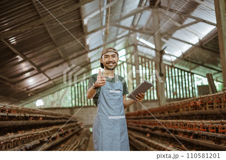 smiling young businessman with thumbs up with tablet on farm 110581201