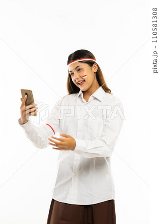 a woman with the ribbon at her head look at the phone 110581308