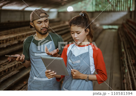 male and female worker worried looking at reports on tablet male and female worker worried looking at reports on tablet 110581394