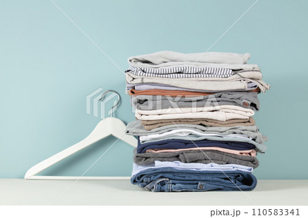 stack of folded clothes, blue background 110583341
