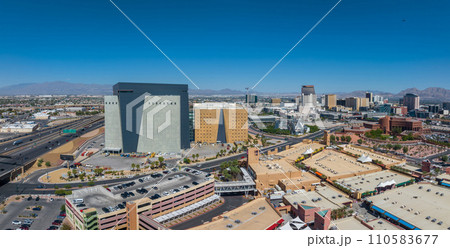 Aerial view of a bustling American cityscape with modern high-rises, surrounded by mountains, clear blue skies, and lush parks in Las Vegas, USA. Aerial view of a bustling American cityscape with modern high-rises, surrounded by mountains, clear blue skies, and lush parks in Las Vegas, USA. 110583677