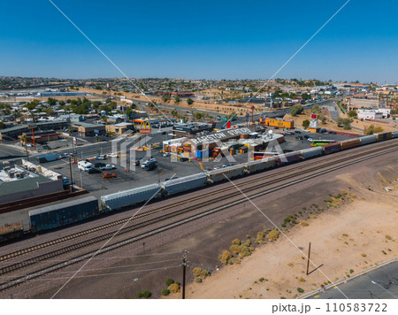 Aerial view of Barstow, a quaint suburb along Route 66, featuring the Barstow Station, parallel railroad tracks, a freight train, and a clear, sunny desert landscape. Aerial view of Barstow, a quaint suburb along Route 66, featuring the Barstow Station, parallel railroad tracks, a freight train, and a clear, sunny desert landscape. 110583722