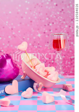 Heart-shaped marshmallows are decorated on a blue-pink checkered surface with props. Outstanding sparkling pink background. Festive atmosphere. Heart-shaped marshmallows are decorated on a blue-pink checkered surface with props. Outstanding sparkling pink background. Festive atmosphere. 110584016