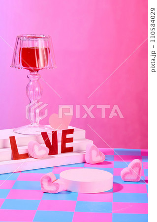 The word LOVE, marshmallow and a decorative glass are displayed on a white podium. Empty podium for product display. Checkered pattern with pink background. The word LOVE, marshmallow and a decorative glass are displayed on a white podium. Empty podium for product display. Checkered pattern with pink background. 110584029