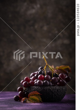 Purple grapes on violet background 110584610