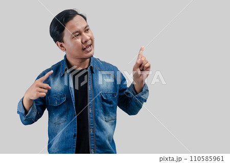 Young asian man pointing hand up to empty space Young asian man pointing hand up to empty space 110585961
