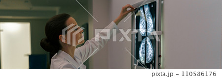Focused professional doctor radiologist analyzing scan MRI images in medical center 110586176
