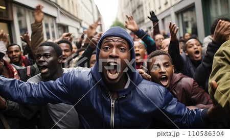 Crowd of angry African immigrants rioted in the city. Portrait of poor African refugees protesting in a European city.  Massive group of African American refugees on a strike. 110586304