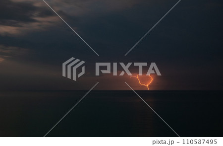 Lightning over the sea during a thunderstorm on a summer night 110587495