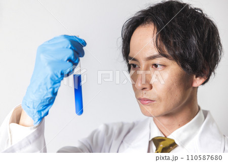 試験管をのぞき込む白衣の男性 110587680