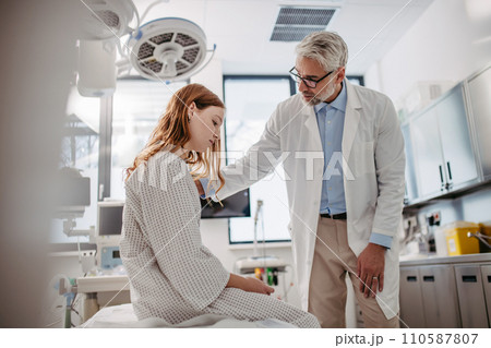 Doctor delivering bad news to teenage patient in hospital, discussing test result in emergency room. Doctor delivering bad news to teenage patient in hospital, discussing test result in emergency room. 110587807