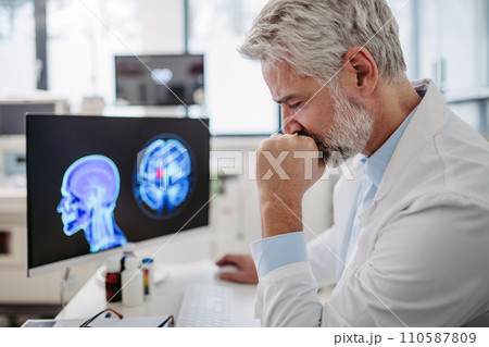Sad doctor looks at an MRI scan, patient's bad test results, feeling helpless. Recurrence of the disease Sad doctor looks at an MRI scan, patient's bad test results, feeling helpless. Recurrence of the disease 110587809
