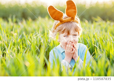 little kid boy having fun with traditional Easter egg hunt little kid boy having fun with traditional Easter egg hunt 110587835
