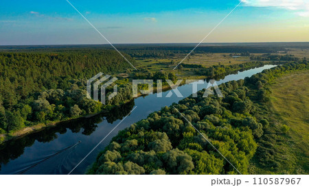 Beautiful aerial shot of an untouched wild river landscape. Gorgeous summer view of a river flowing through the untouched forest on a bright spring day. A drone shot of a wild natural river terrain. 110587967