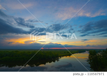 Beautiful aerial shot of an untouched wild river landscape. Gorgeous summer view of a river flowing through the untouched forest at sunset. A drone shot of a wild natural river terrain. Beautiful aerial shot of an untouched wild river landscape. Gorgeous summer view of a river flowing through the untouched forest at sunset. A drone shot of a wild natural river terrain. 110587971