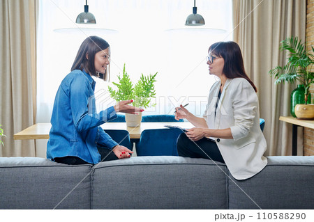 Happy young woman patient talking to female psychologist at therapy Happy young woman patient talking to female psychologist at therapy 110588290