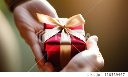 Close-up of female hands holding a present 110589467