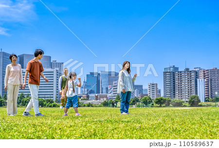 公園を駆けっこをする家族三世代 110589637