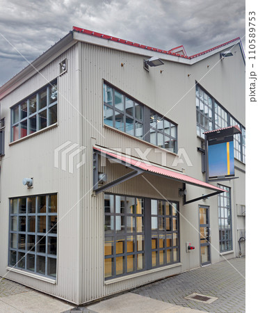 Corner of an office and production building on stormy sky background 110589753