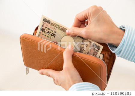 財布からお札を取り出すミドル女性の手元 財布からお札を取り出すミドル女性の手元 110590283
