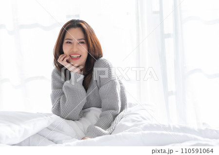 Stunning Beautiful Attractive Asian young woman sit on bed looking at camera and smile happiness and comfortable at home.Cute girl smile cross arm confident and relax in bed room Stunning Beautiful Attractive Asian young woman sit on bed looking at camera and smile happiness and comfortable at home.Cute girl smile cross arm confident and relax in bed room 110591064
