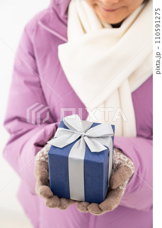プレゼントを持つ冬服姿のミドル女性 110591275