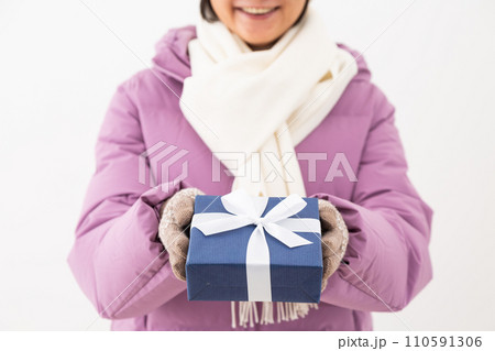 プレゼントを持つ冬服姿のミドル女性 110591306