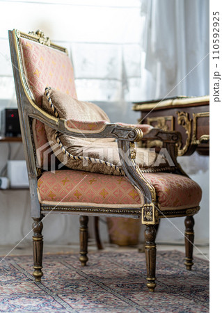 Image of Old antique vintage wooden chair with pillow in pastel colours 110592925