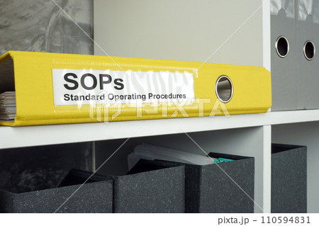 SOP Standard operating procedure concept. A yellow folder lies on an office shelf. SOP Standard operating procedure concept. A yellow folder lies on an office shelf. 110594831