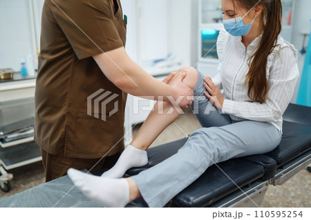 Doctor examining female patient with injured leg. Osteopathy, Chiropractic leg adjustment. 110595254