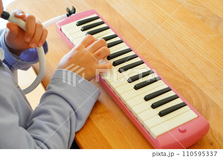 小学4年生の女の子が鍵盤ハーモニカを演奏している様子。 110595337