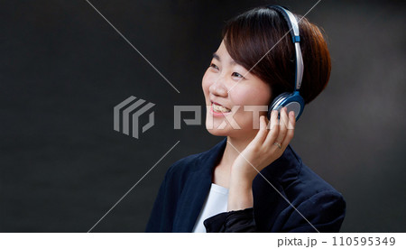 ヘッドフォンで音楽を聴く若い女性 110595349