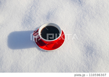 Red ceramic cup of espresso coffee on snow background of a winter landscape  110596307