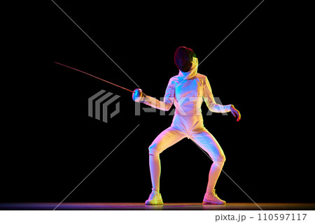Martial arts and discipline. Fencing, martial art requiring discipline and strategy, perfect for related themes. Female athlete training over black background in neon. 110597117