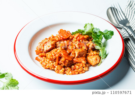 Ptitim with chicken, vegetables and cilantro, white background. Traditional Israeli food. 110597671